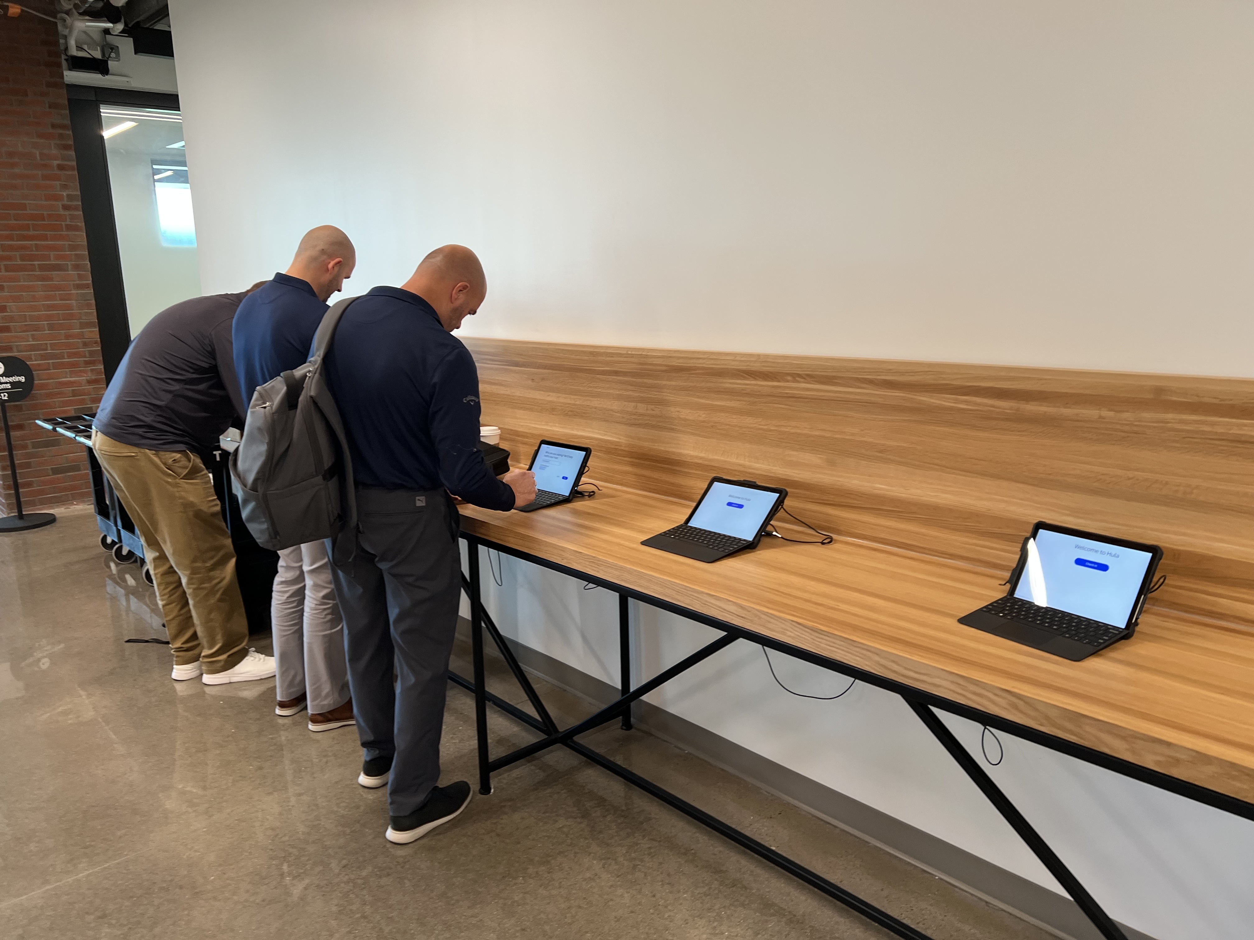 Two visitors using the check-in kiosks at Bentonville HQ before the new design launched